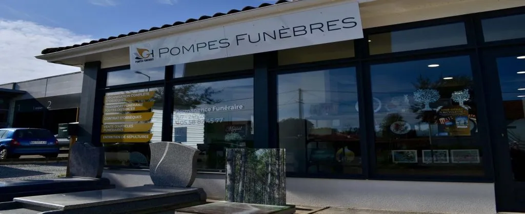 Devanture d'agence de pompes funèbres avec exposition de monuments funéraires