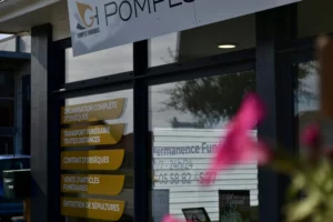 Gros plan sur la vitrine d'une agence de pompes funèbres affichant la liste des services proposés