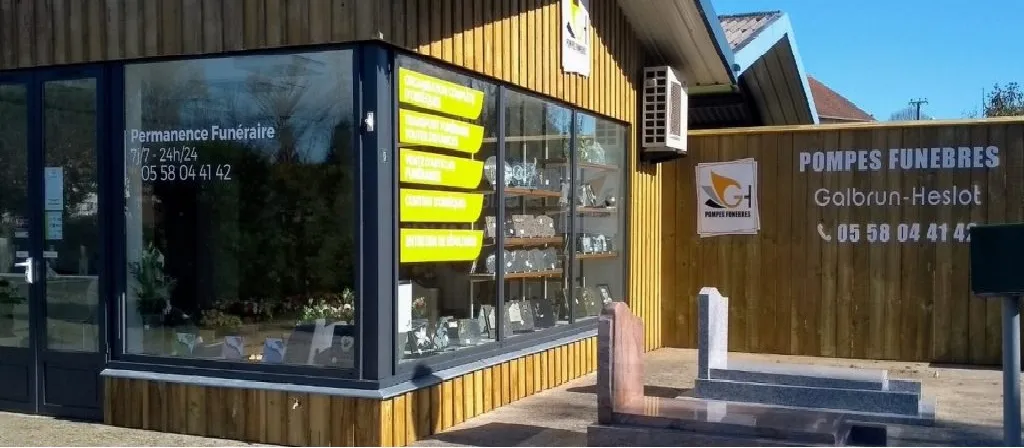 Façade en bois de l'agence de pompes funèbres Galbrun-Heslot avec vitrine et monuments funéraires